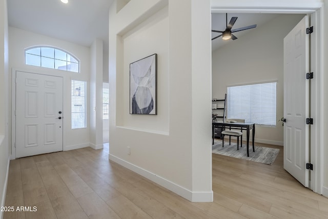 entrance foyer with ceiling fan, high vaulted ceiling, and light wood-type flooring