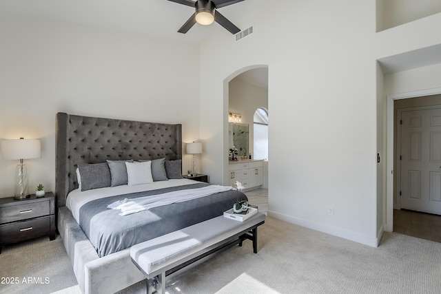 carpeted bedroom featuring ceiling fan and ensuite bath