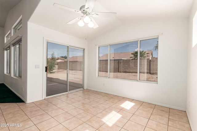 spare room featuring baseboards, ceiling fan, vaulted ceiling, and light tile patterned flooring