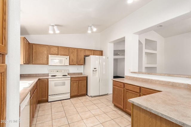 kitchen featuring white appliances, light tile patterned flooring, vaulted ceiling, and light countertops