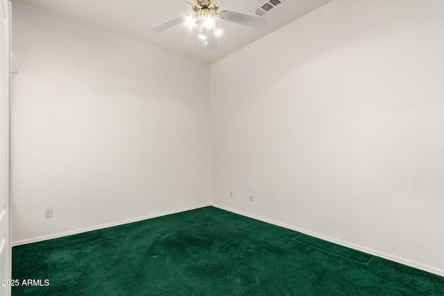 spare room with baseboards, a ceiling fan, dark colored carpet, and visible vents