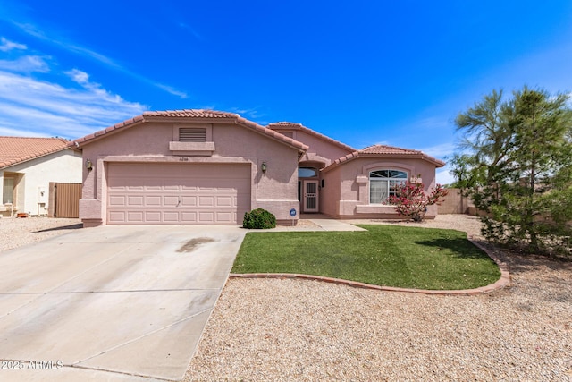 view of front of home featuring an attached garage, a tile roof, stucco siding, a front yard, and driveway