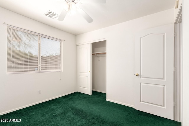 unfurnished bedroom with visible vents, a closet, baseboards, dark carpet, and a ceiling fan