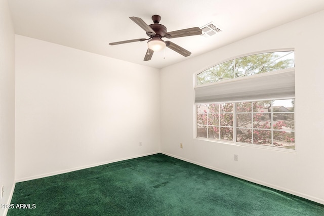 carpeted empty room featuring visible vents, a ceiling fan, and baseboards