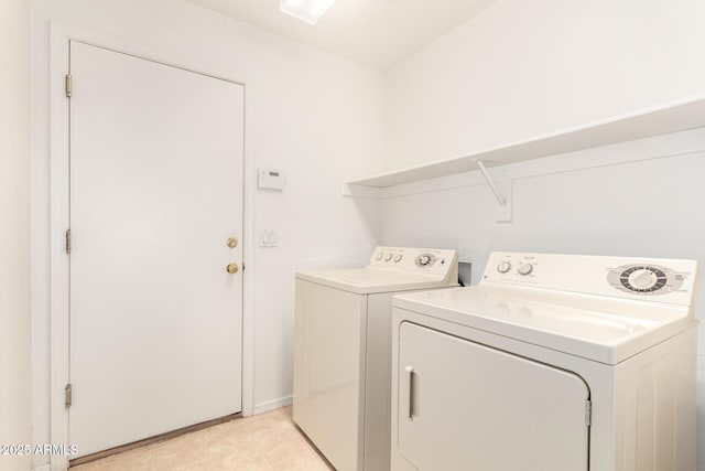washroom with light tile patterned floors, laundry area, and washer and dryer