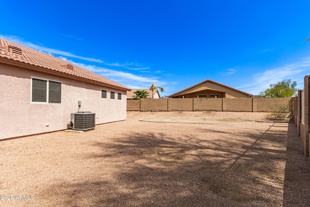 view of yard featuring a fenced backyard and central AC