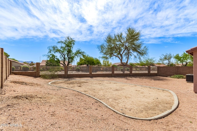 view of yard with central AC and fence