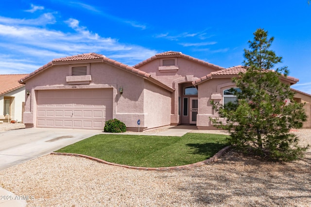 mediterranean / spanish-style house with driveway, a tile roof, a front yard, a garage, and stucco siding