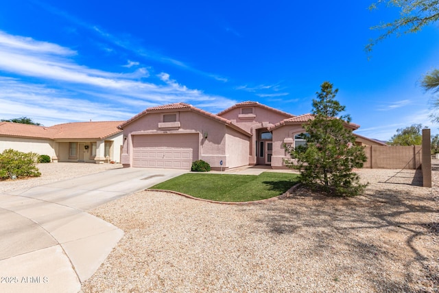 mediterranean / spanish home featuring fence, a tile roof, a garage, stucco siding, and driveway