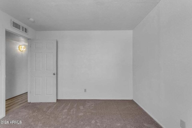 carpeted spare room with a textured ceiling