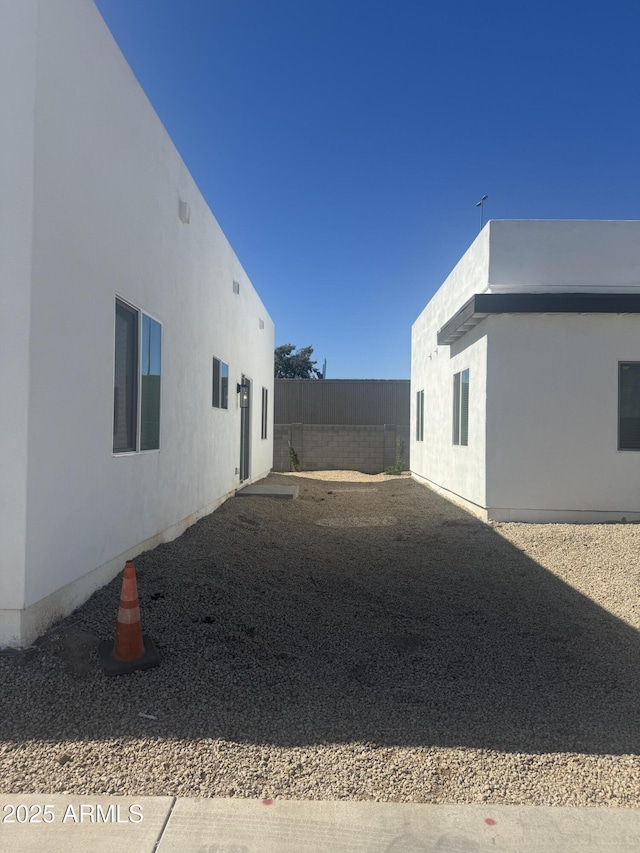 view of home's exterior featuring a patio area, fence, and stucco siding