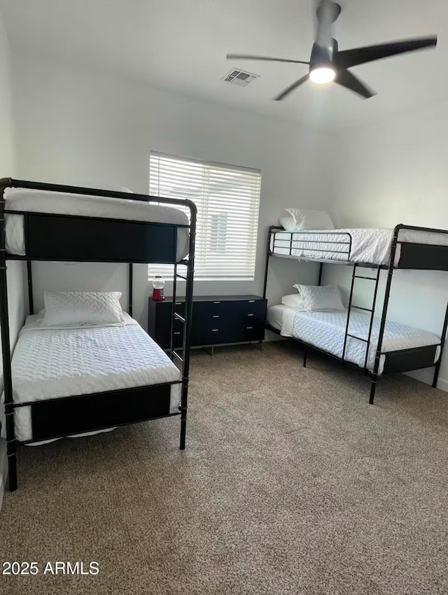 carpeted bedroom with visible vents and a ceiling fan