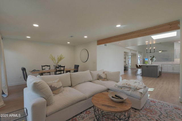 living room with lofted ceiling with beams, baseboards, light wood-style flooring, and recessed lighting