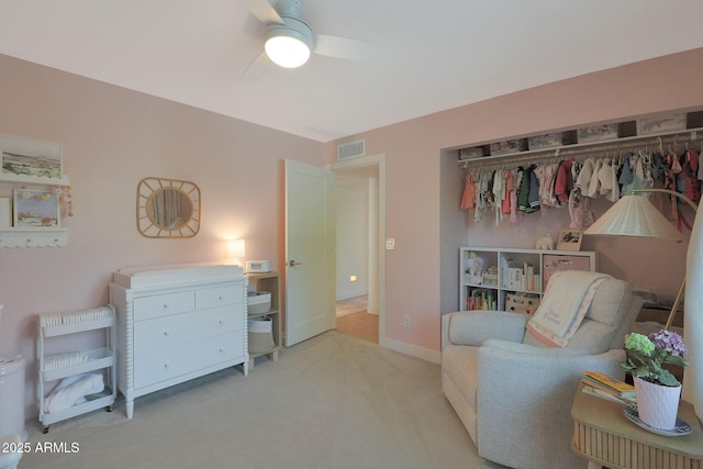 living area featuring light carpet, visible vents, baseboards, and a ceiling fan