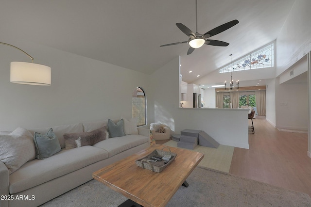 living room with recessed lighting, visible vents, light wood-style floors, high vaulted ceiling, and ceiling fan with notable chandelier