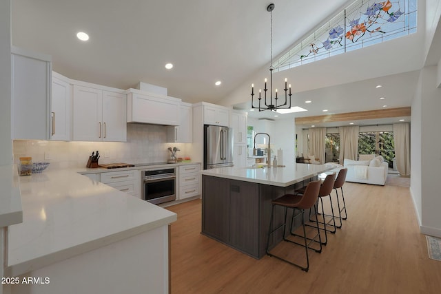 kitchen with stainless steel appliances, white cabinetry, and light countertops