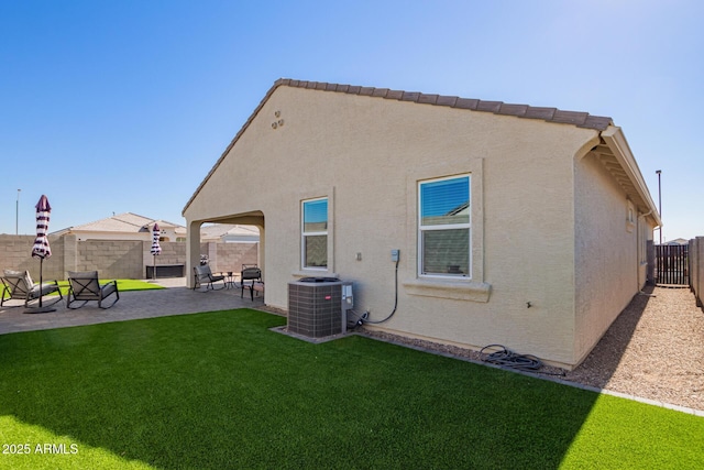 rear view of house with a yard, central AC, and a patio