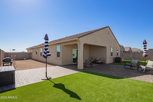 rear view of house with a patio, a yard, and cooling unit