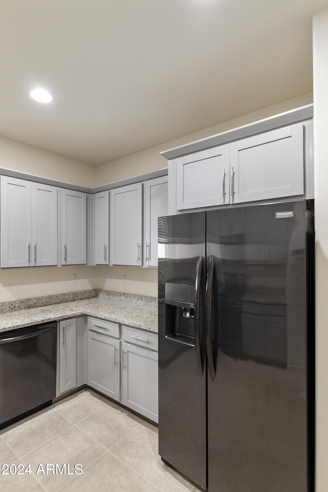 kitchen featuring black appliances, gray cabinets, light tile patterned flooring, and light stone countertops