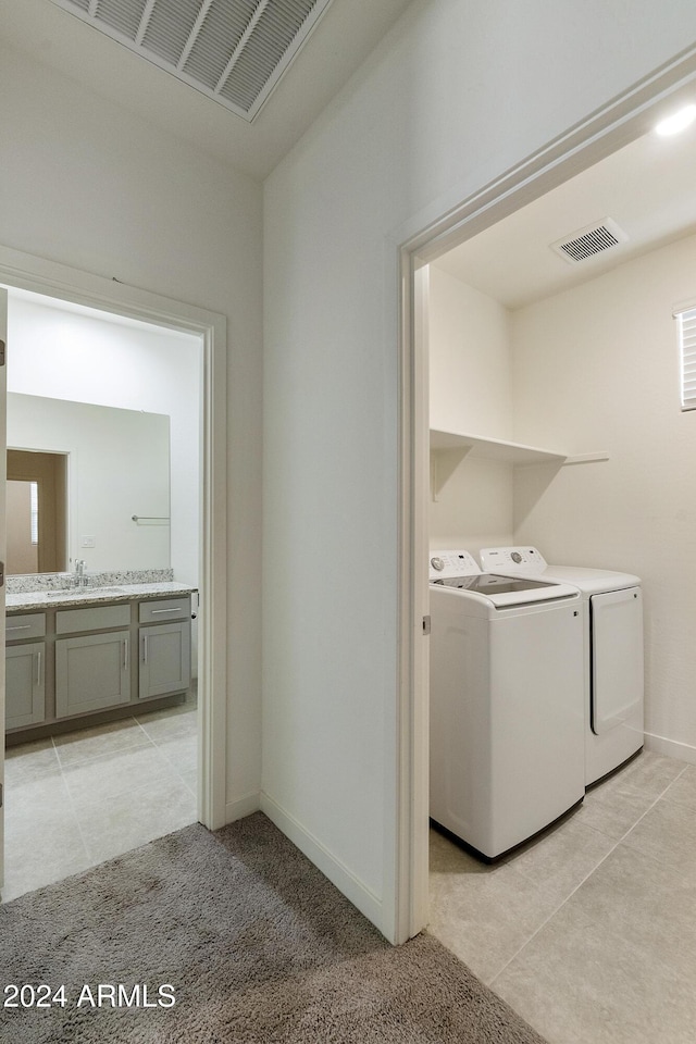 clothes washing area with independent washer and dryer and light tile patterned floors