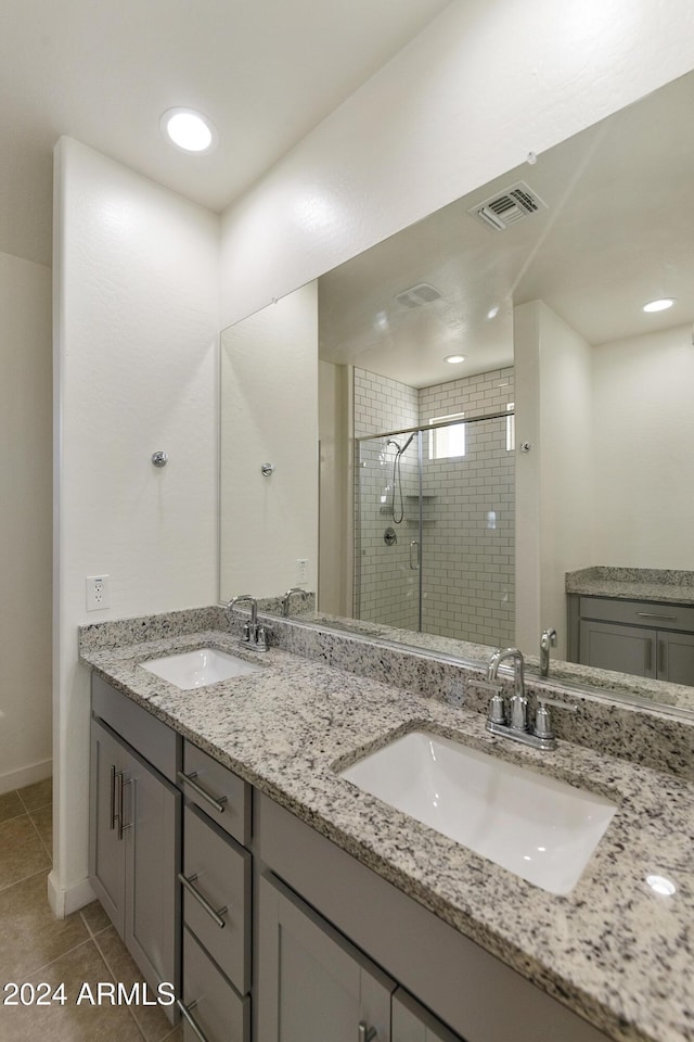 bathroom with tile patterned flooring, vanity, and a shower with shower door