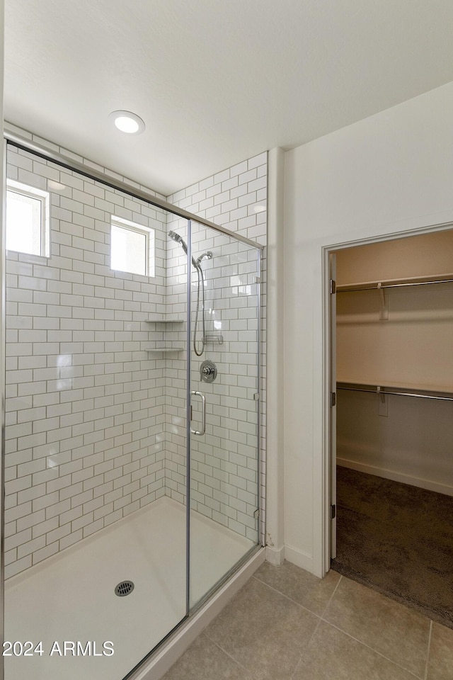 bathroom with tile patterned flooring and a shower with door