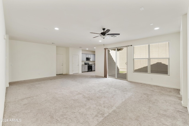 unfurnished living room featuring ceiling fan and light colored carpet