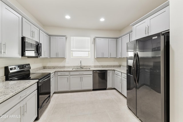 kitchen with light stone counters, gray cabinetry, stainless steel appliances, sink, and light tile patterned floors