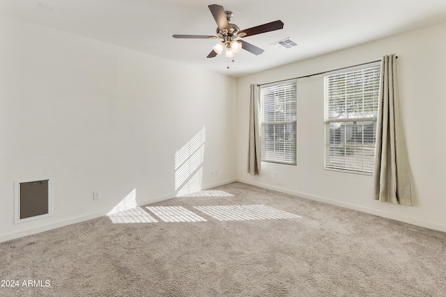 carpeted spare room featuring ceiling fan