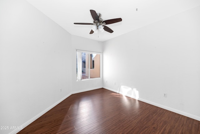 unfurnished room with a ceiling fan, baseboards, and dark wood-style flooring
