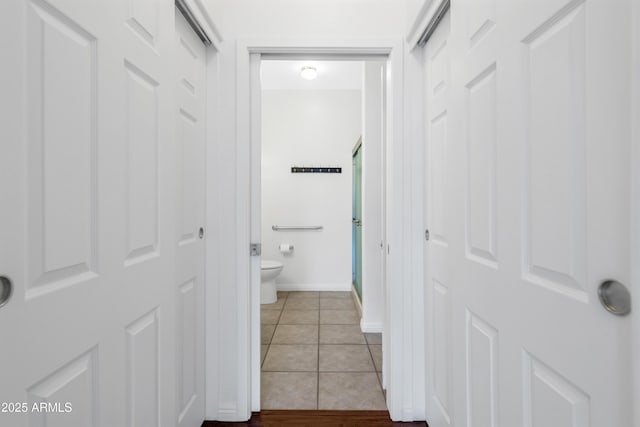 bathroom featuring tile patterned flooring, toilet, and baseboards