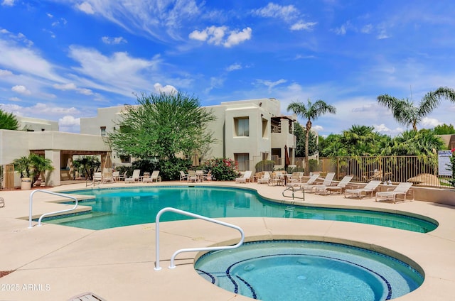 pool featuring a community hot tub, a patio, and fence