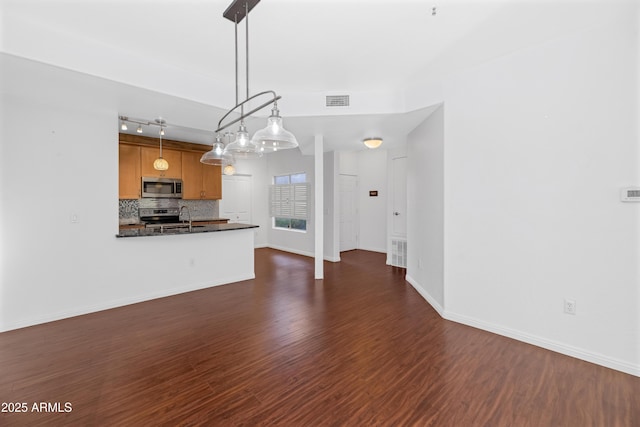 unfurnished living room with dark wood-style floors, visible vents, and baseboards