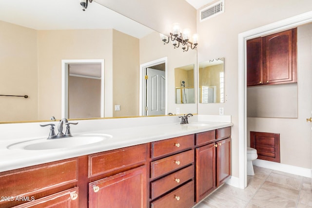 bathroom with toilet, vanity, and a notable chandelier