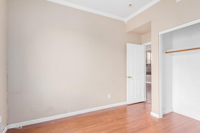 unfurnished bedroom featuring light wood-type flooring, a closet, and ornamental molding