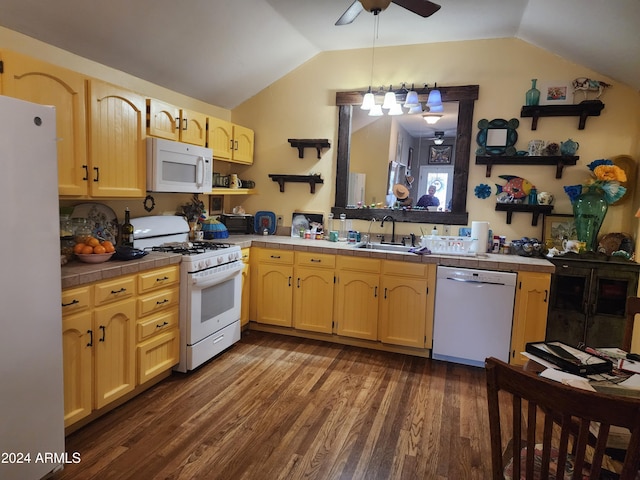 kitchen with white appliances, vaulted ceiling, dark wood-type flooring, sink, and tile counters