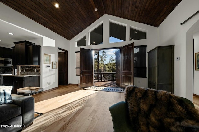 living room featuring wood ceiling, high vaulted ceiling, and light wood-type flooring