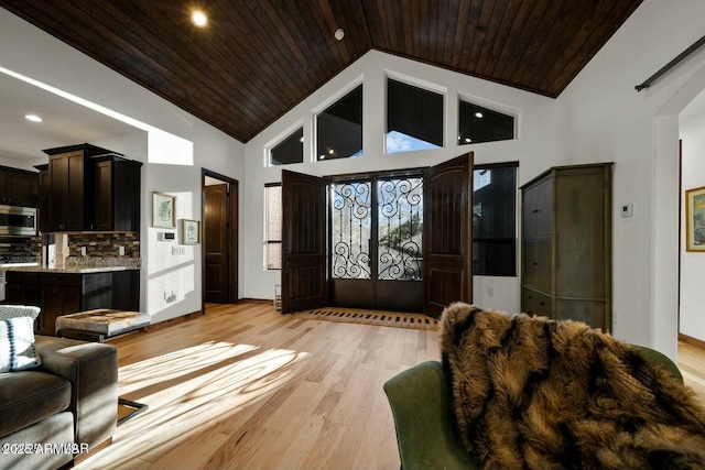 foyer entrance featuring wooden ceiling, high vaulted ceiling, and light hardwood / wood-style flooring