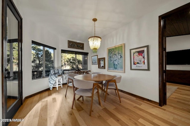 dining space featuring a notable chandelier and light wood-type flooring