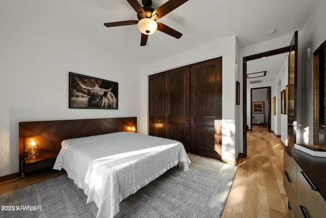 bedroom featuring light hardwood / wood-style flooring, a closet, and ceiling fan