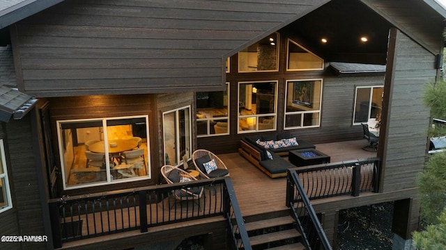 rear view of house featuring a wooden deck and an outdoor fire pit