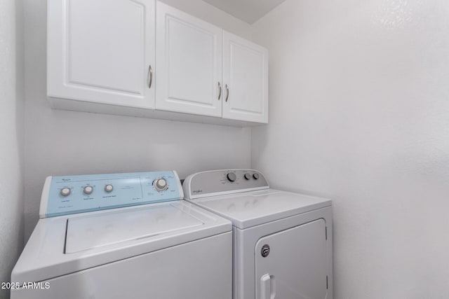 washroom featuring cabinet space and washing machine and clothes dryer