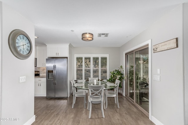 dining area featuring visible vents, baseboards, and light wood-style floors