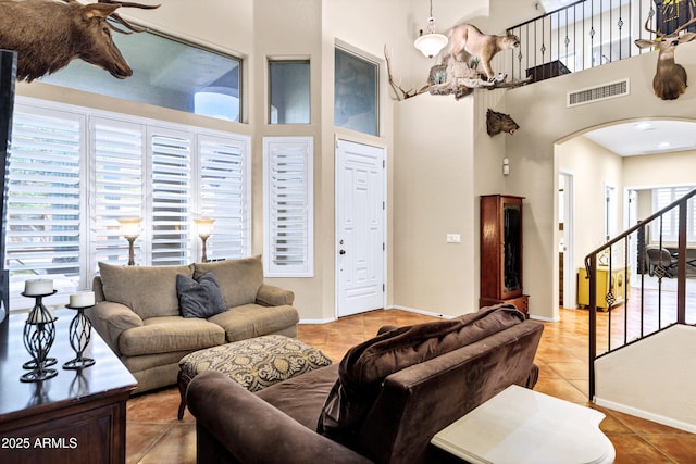 2758 N Sterling, Mesa, AZ 85207 - living room featuring arched walkways, a towering ceiling, light tile patterned flooring, and baseboards