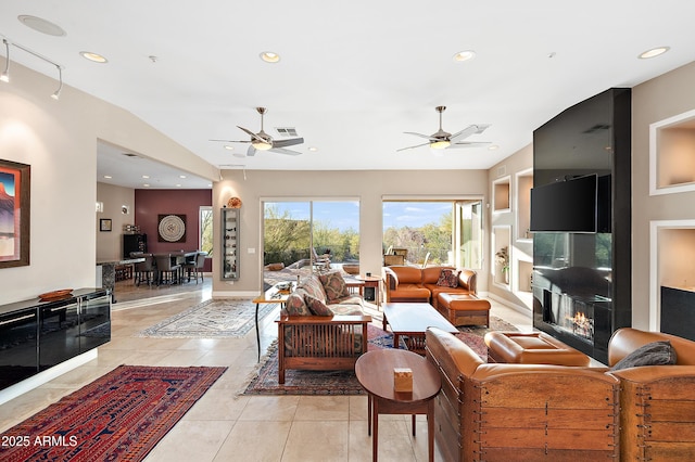 living room with light tile patterned flooring, ceiling fan, and a fireplace