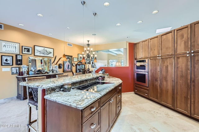 kitchen with a center island, a kitchen breakfast bar, double oven, decorative light fixtures, and electric stovetop