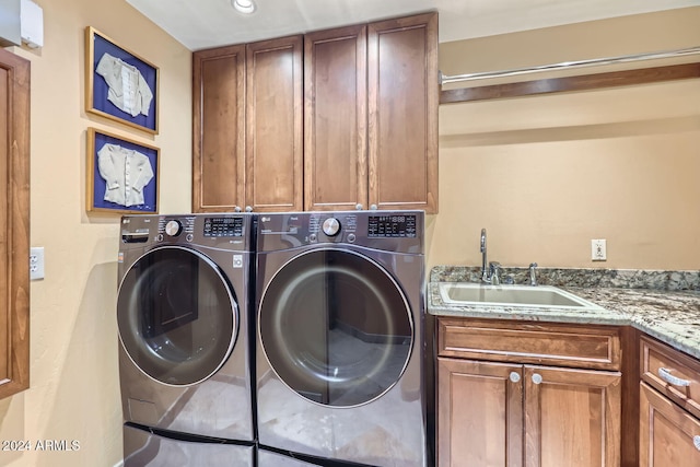 laundry room featuring washing machine and dryer, sink, and cabinets