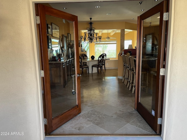 hall with french doors and a chandelier