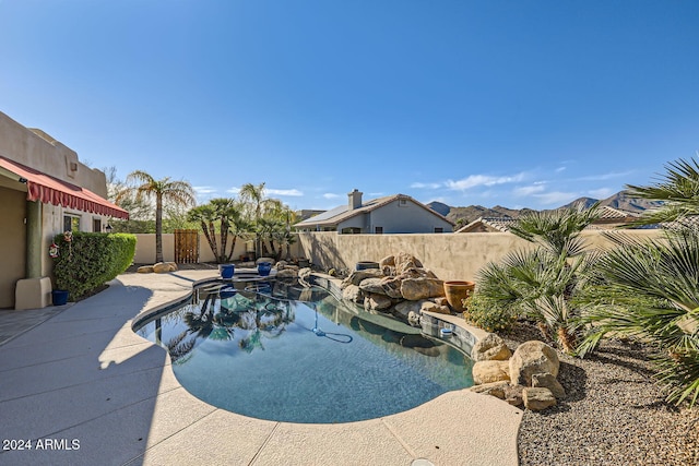 view of swimming pool featuring a mountain view and a patio