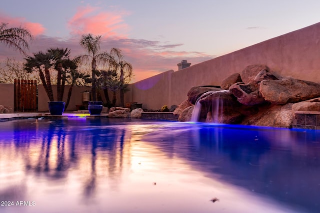 pool at dusk with pool water feature